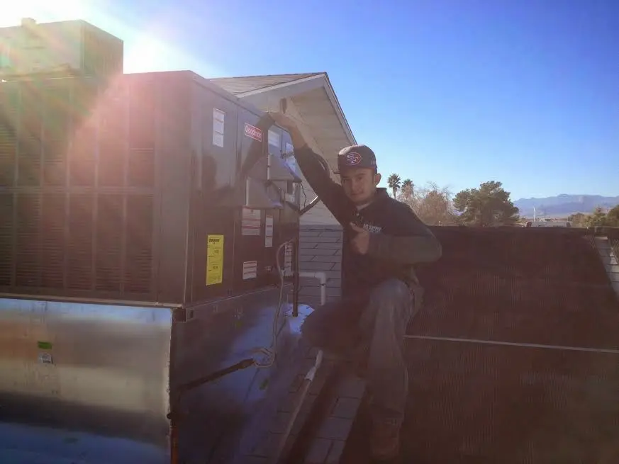 HVAC technician performing Boiler Repair on a rooftop unit in Macedon